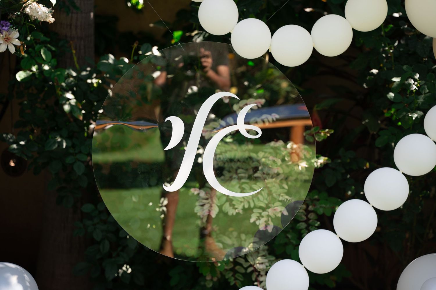 White balloon decorations and floral arrangements create an enchanting outdoor party setting.