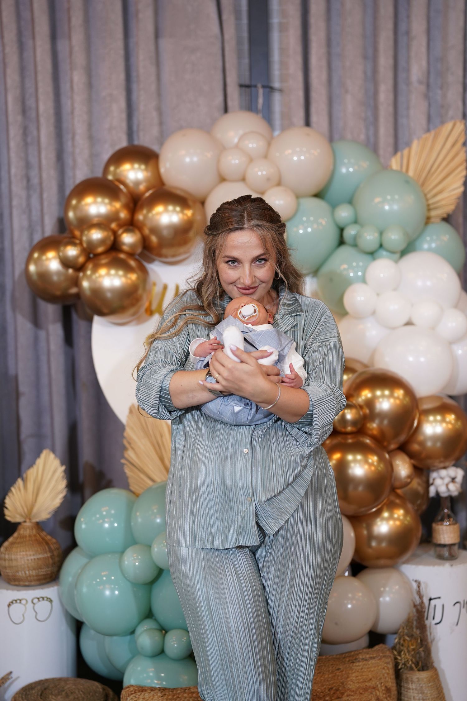 Heartwarming scene at a baby shower with mint and gold balloon decorations.