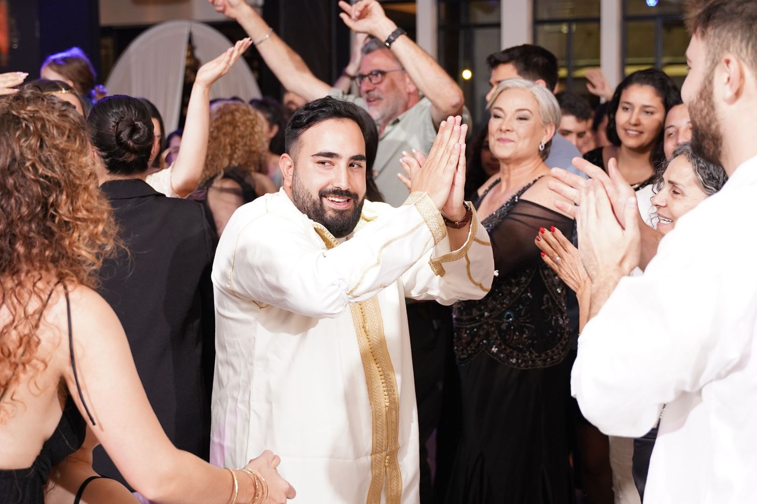 Party guests dancing and celebrating at a festive indoor event.