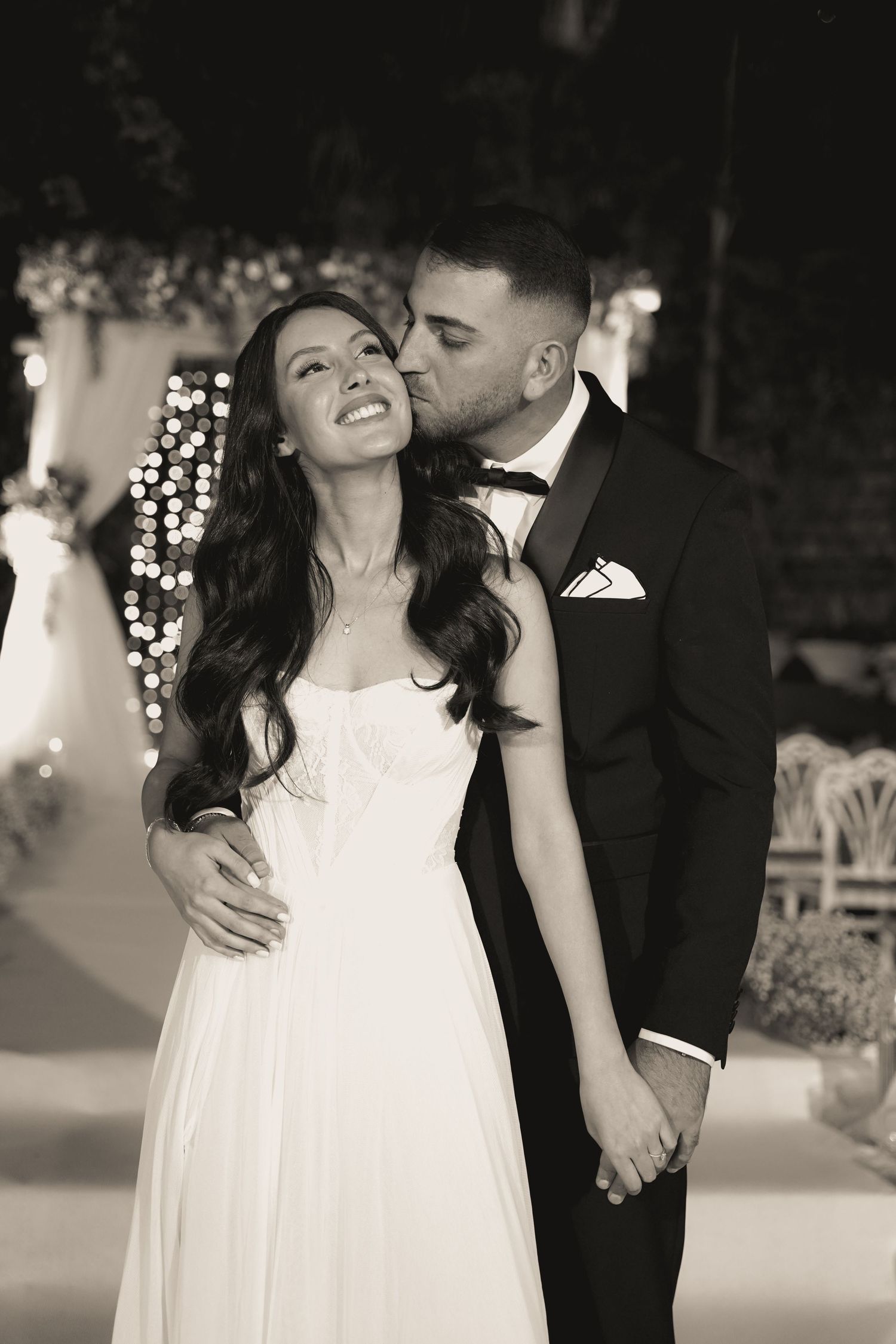 A romantic black and white portrait of a couple sharing an intimate moment at their wedding.