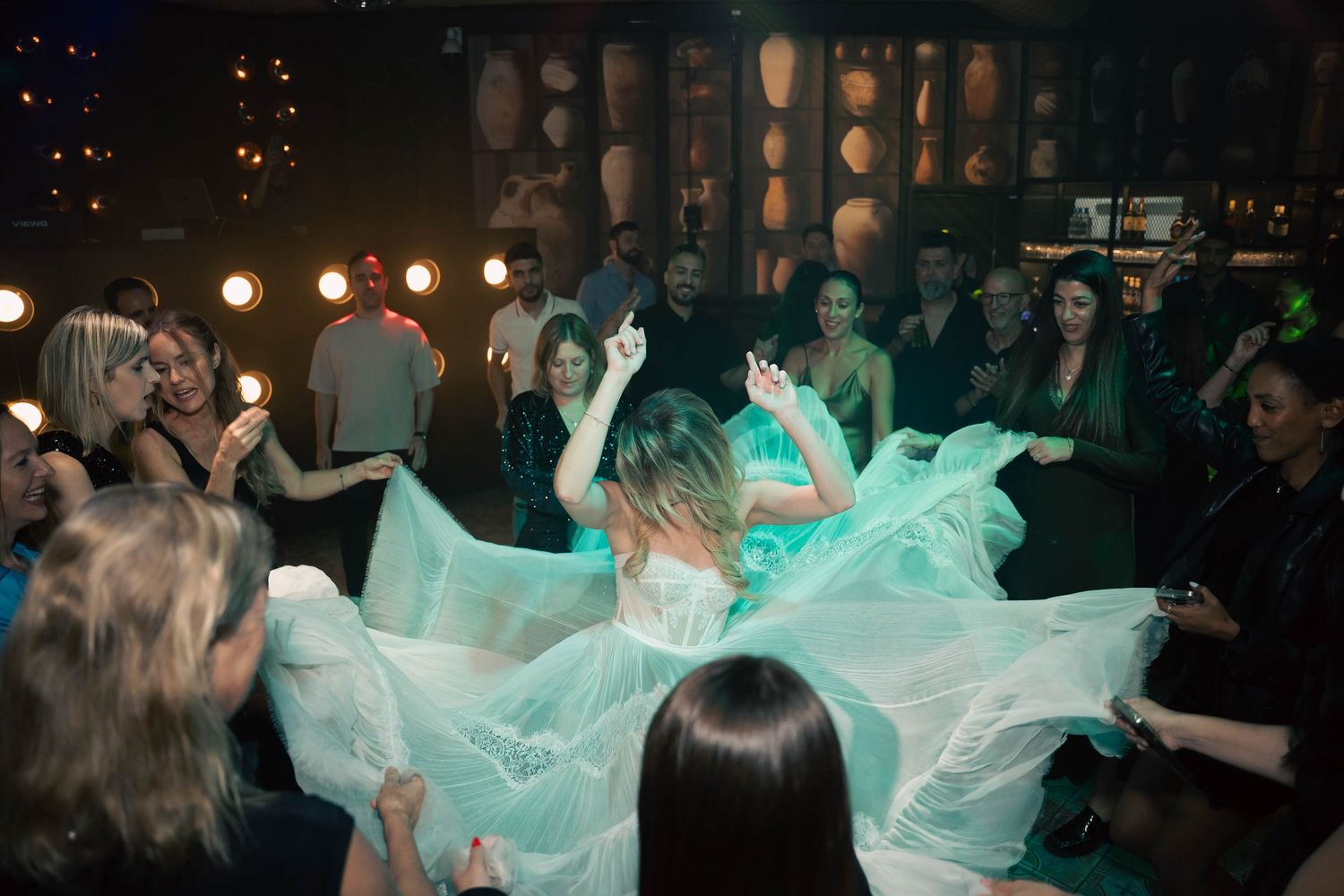 Wedding celebration with flowing aqua fabric creating dramatic movement on the dance floor.
