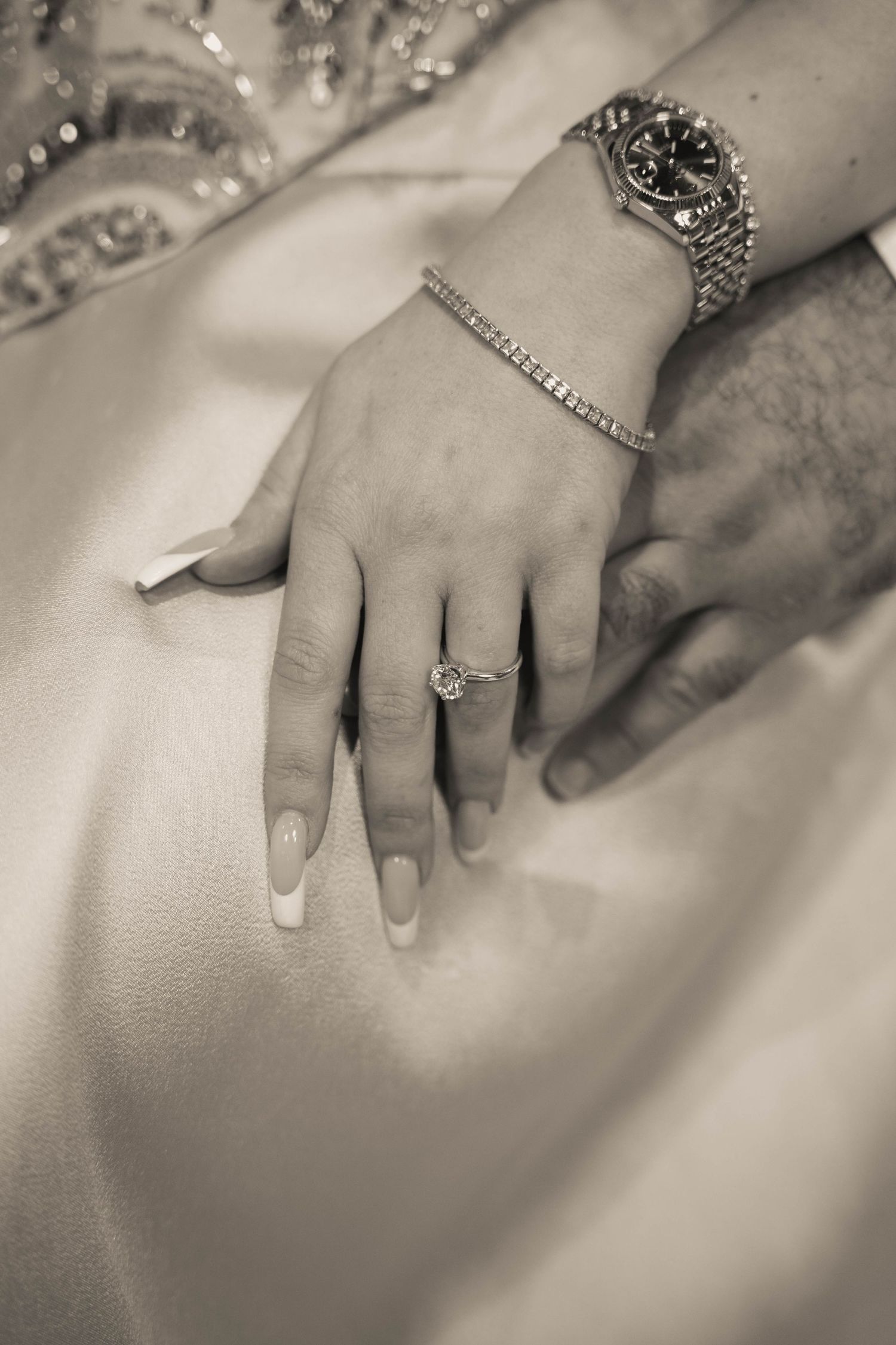 Close-up black and white photo series of hands wearing elegant rings and jewelry against a soft white background.