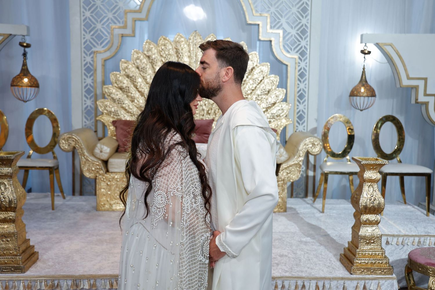 A romantic moment captured in an elegantly decorated room with gold accents.