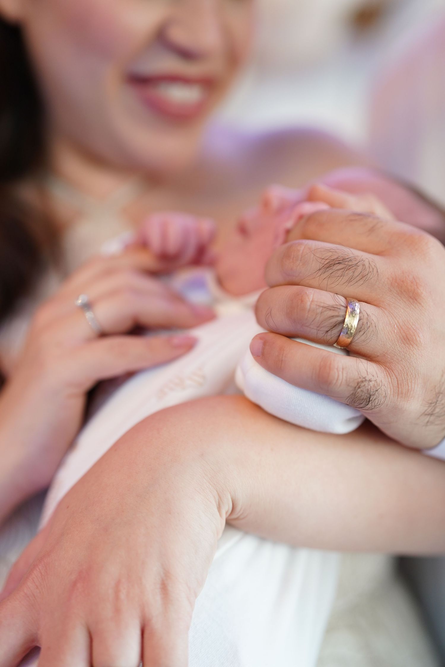 Close-up of hands with wedding rings during intimate moment.