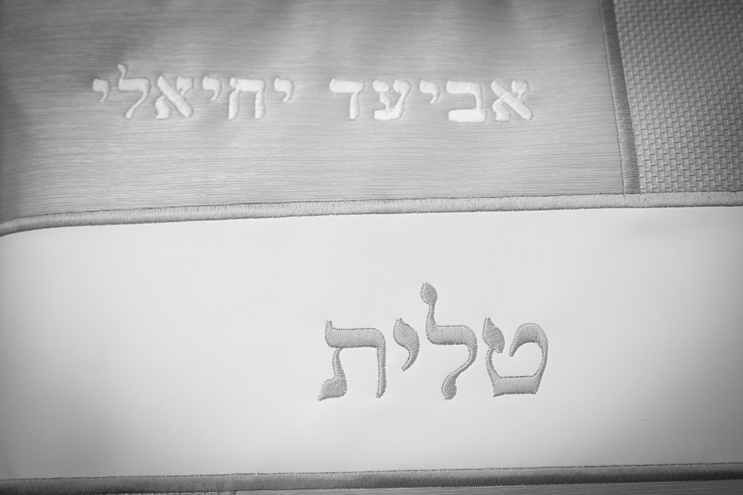 Hebrew text displayed on a light colored wall or surface.