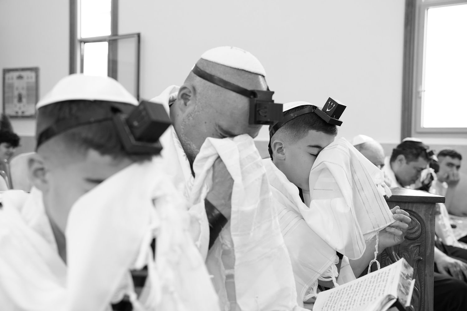 Students in white attire studying together in a classroom setting.