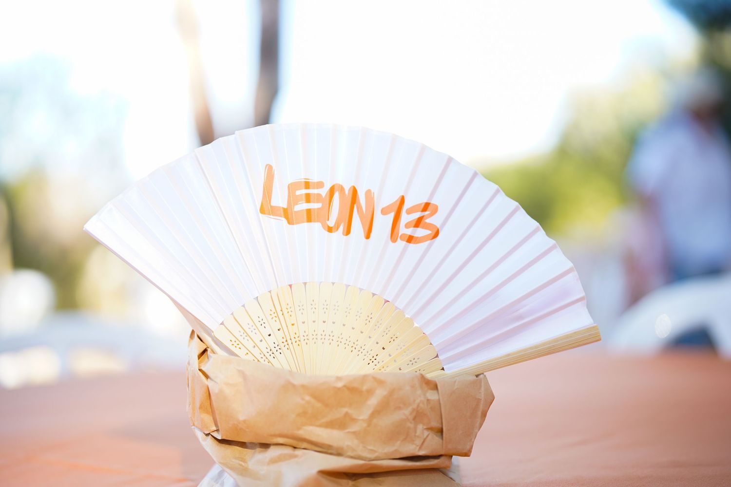 White paper fans arranged decoratively on wooden surface in outdoor setting.