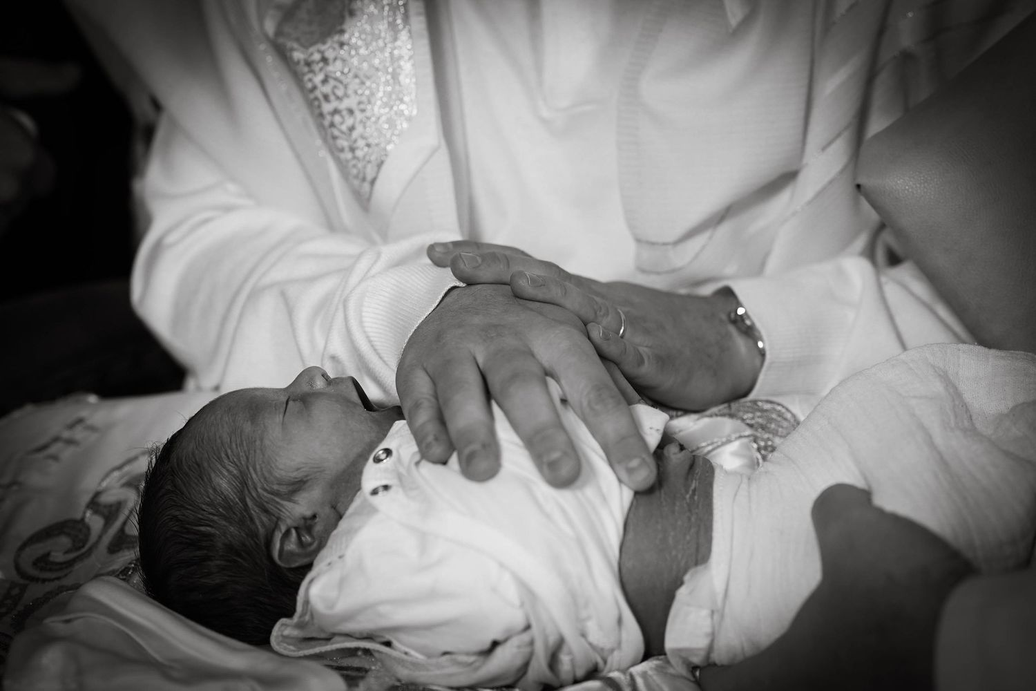 Black and white series of tender moments with a newborn during a professional photoshoot.