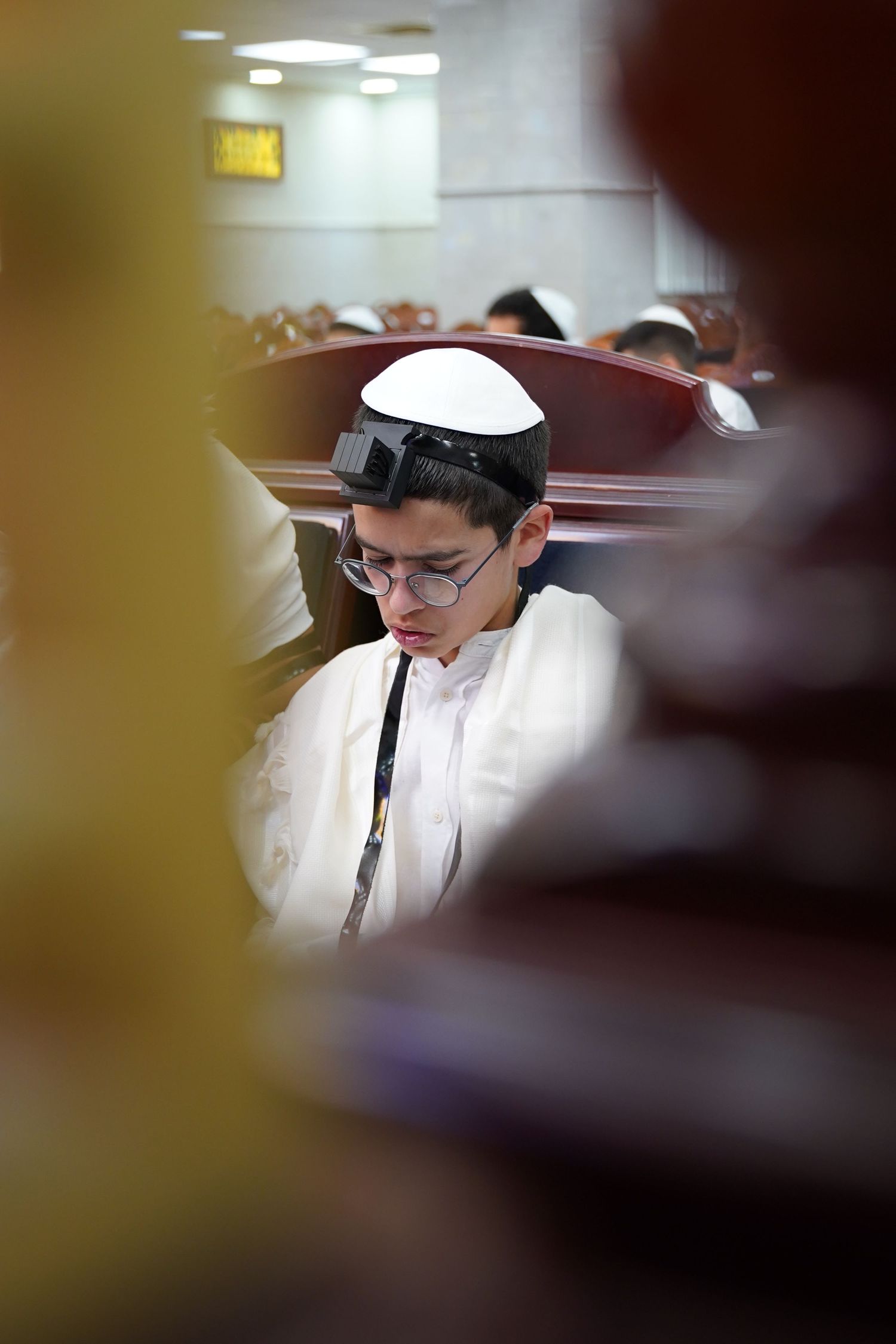Person studying religious texts at desk in indoor setting.