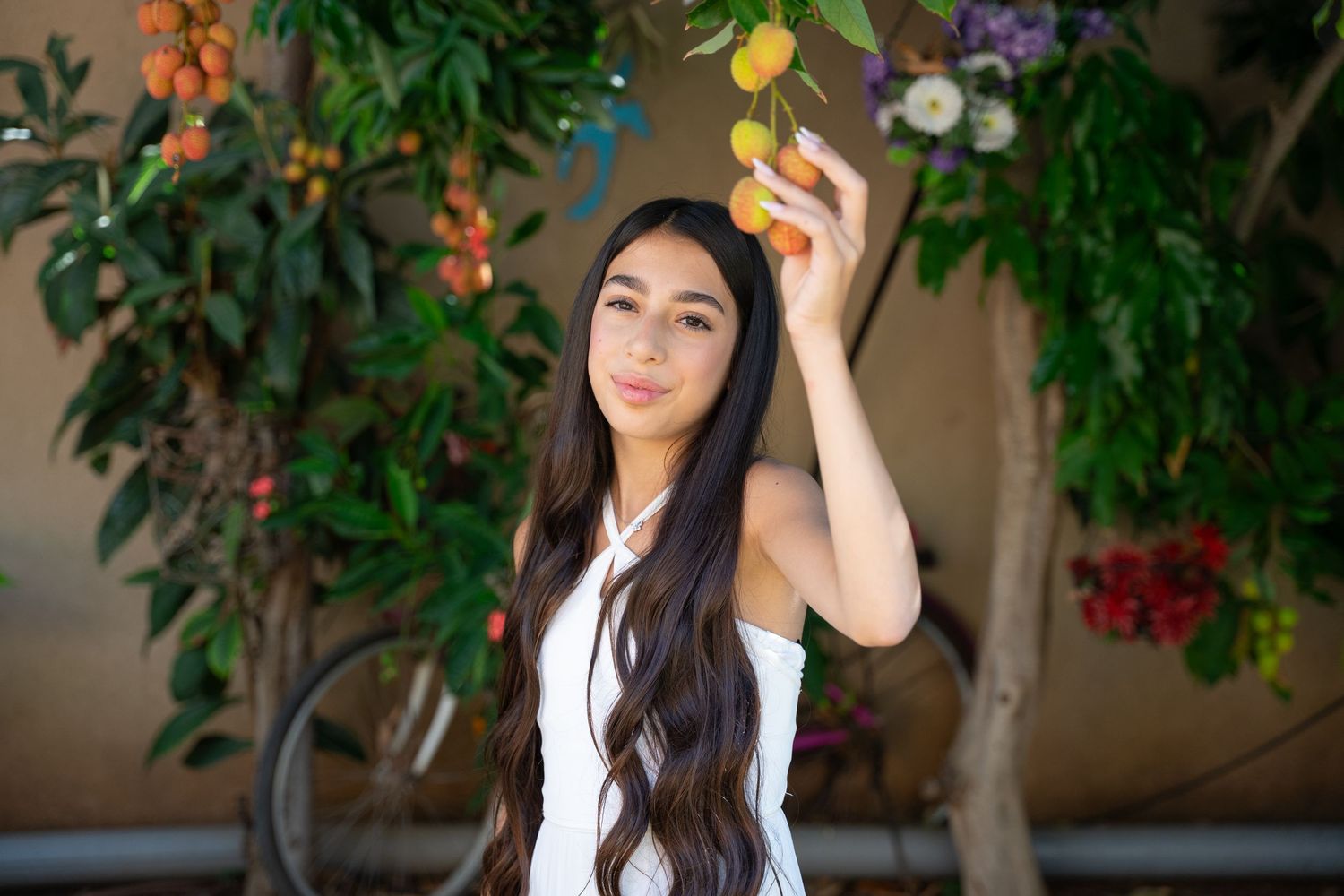 Outdoor portrait session under trees with citrus fruits and greenery.