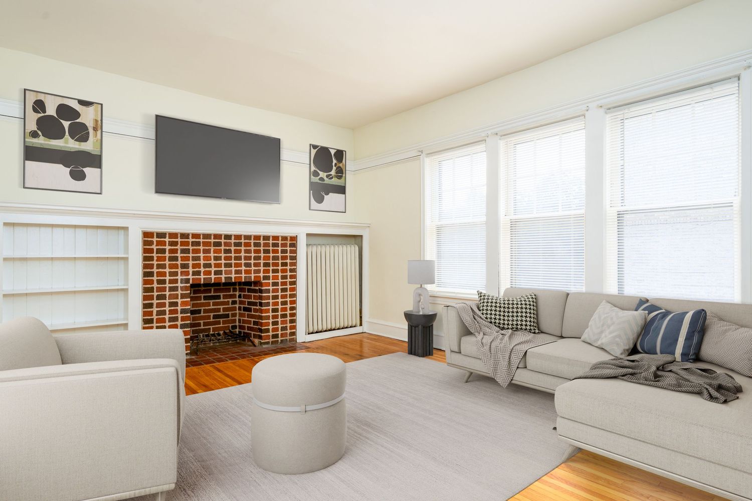 Modern living room with grey sectional sofa, brick mantle, mounted TV, and built-in wood wine storage rack.
