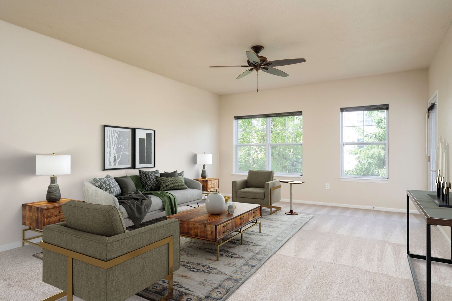 Bright living room with gray sofa, ceiling fan, large windows, and neutral carpet flooring in a modern apartment.