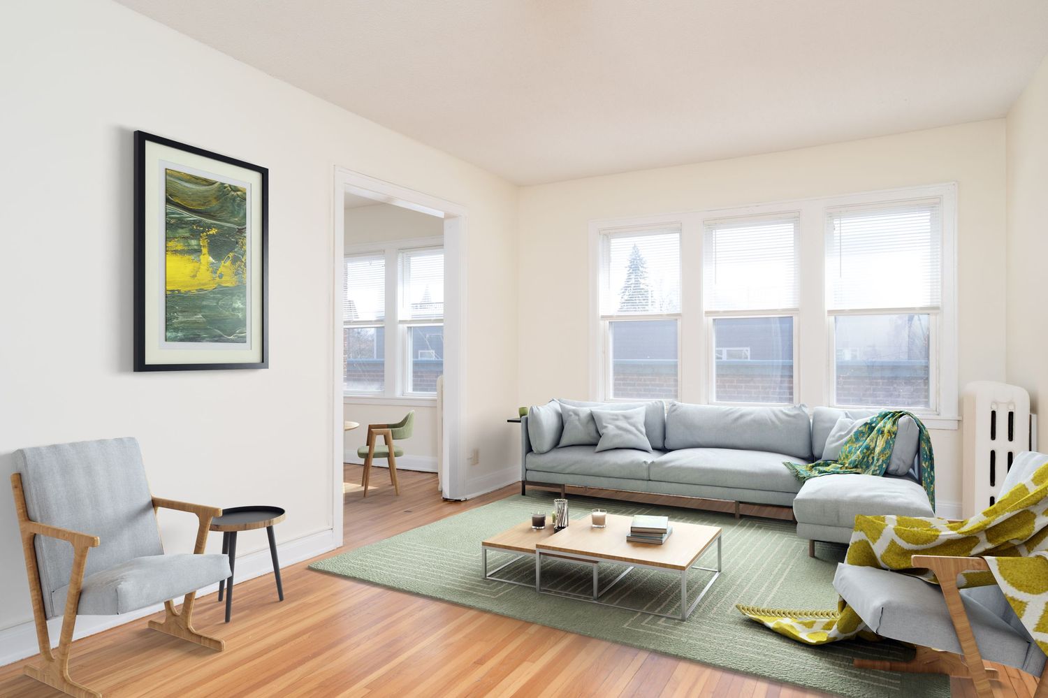 Bright living room with hardwood floors, gray sectional sofa, green rug, modern coffee table, and large windows.
