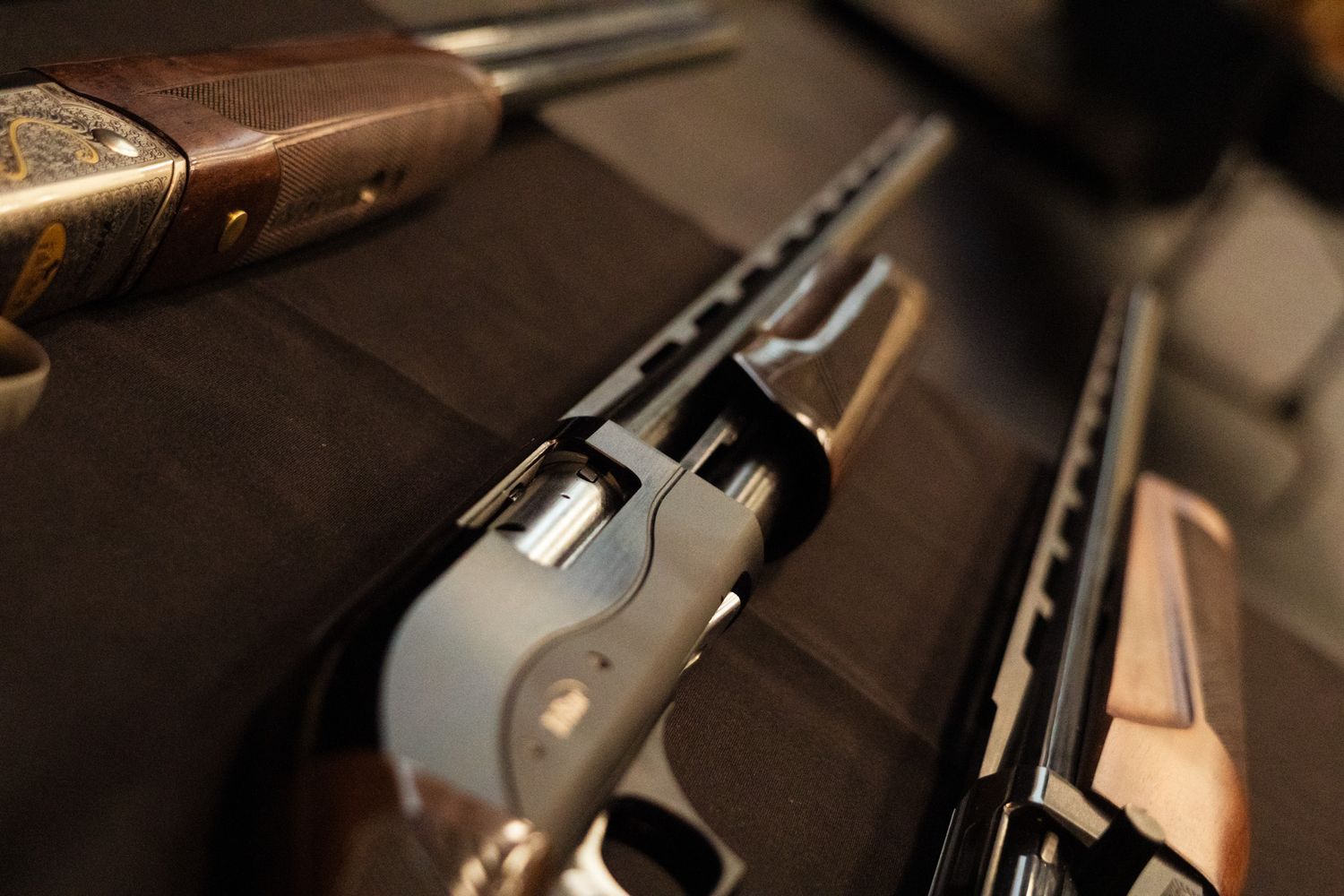 Close-up of an open shotgun mechanism on dark fabric background.