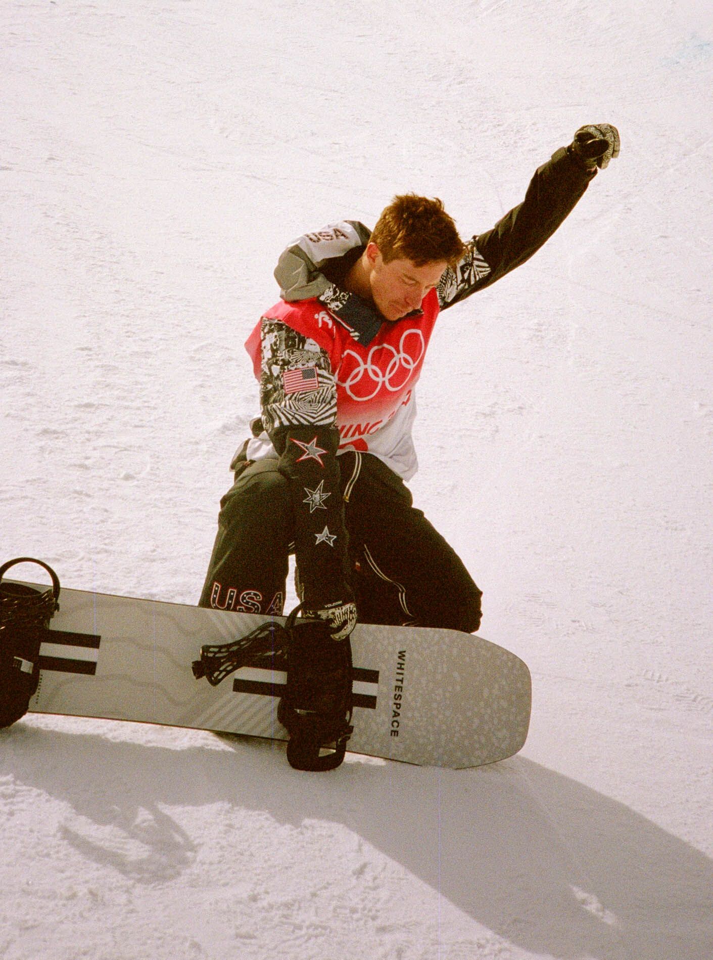 Snowboarder performs aerial trick during Olympic competition.