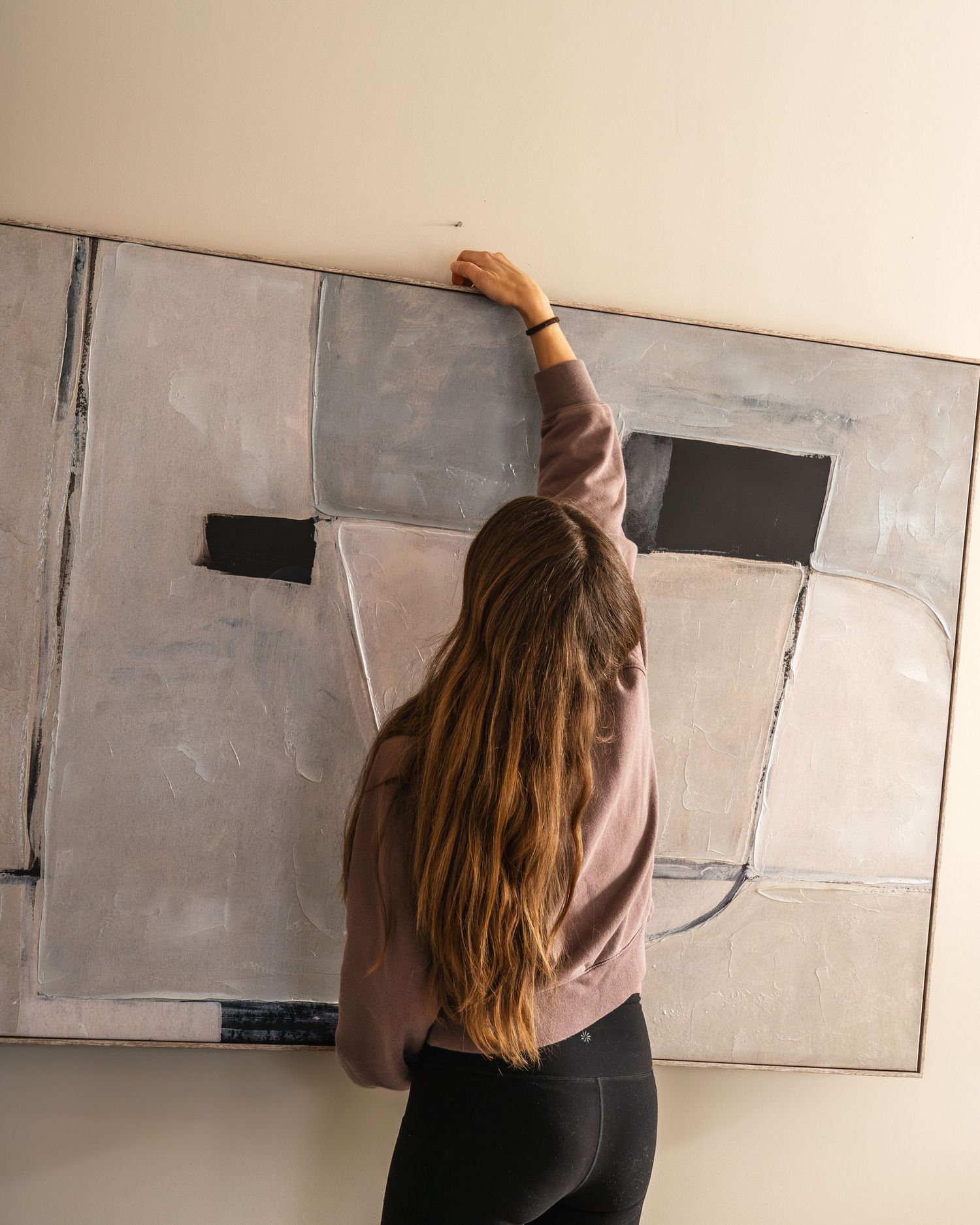 Person in brown sweater writes on a large whiteboard in sequence of connected images showing progressive writing motion.