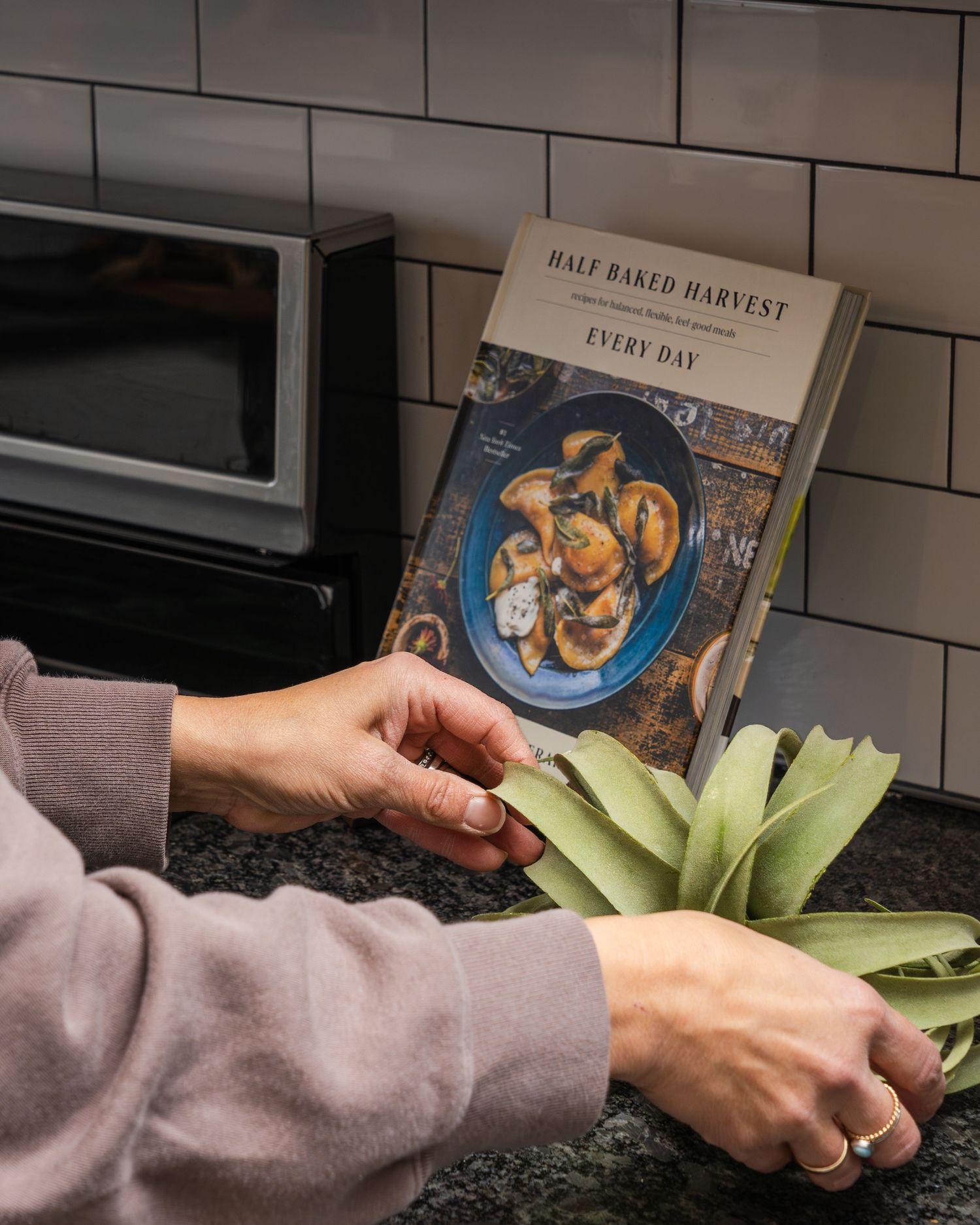 Hands demonstrate how to cut leeks by slicing lengthwise and removing the green parts in a kitchen setting.