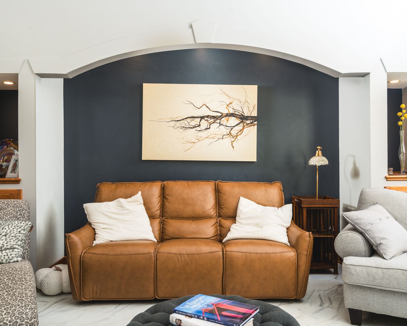 Modern living room design with blue-green walls, brown leather sofa, and sleek contemporary decor.