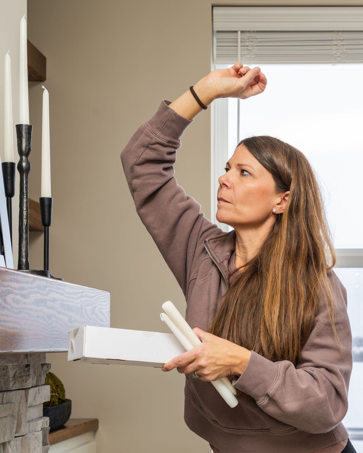 A series of photos showing someone stretching and reaching upward while standing in a room with window blinds.