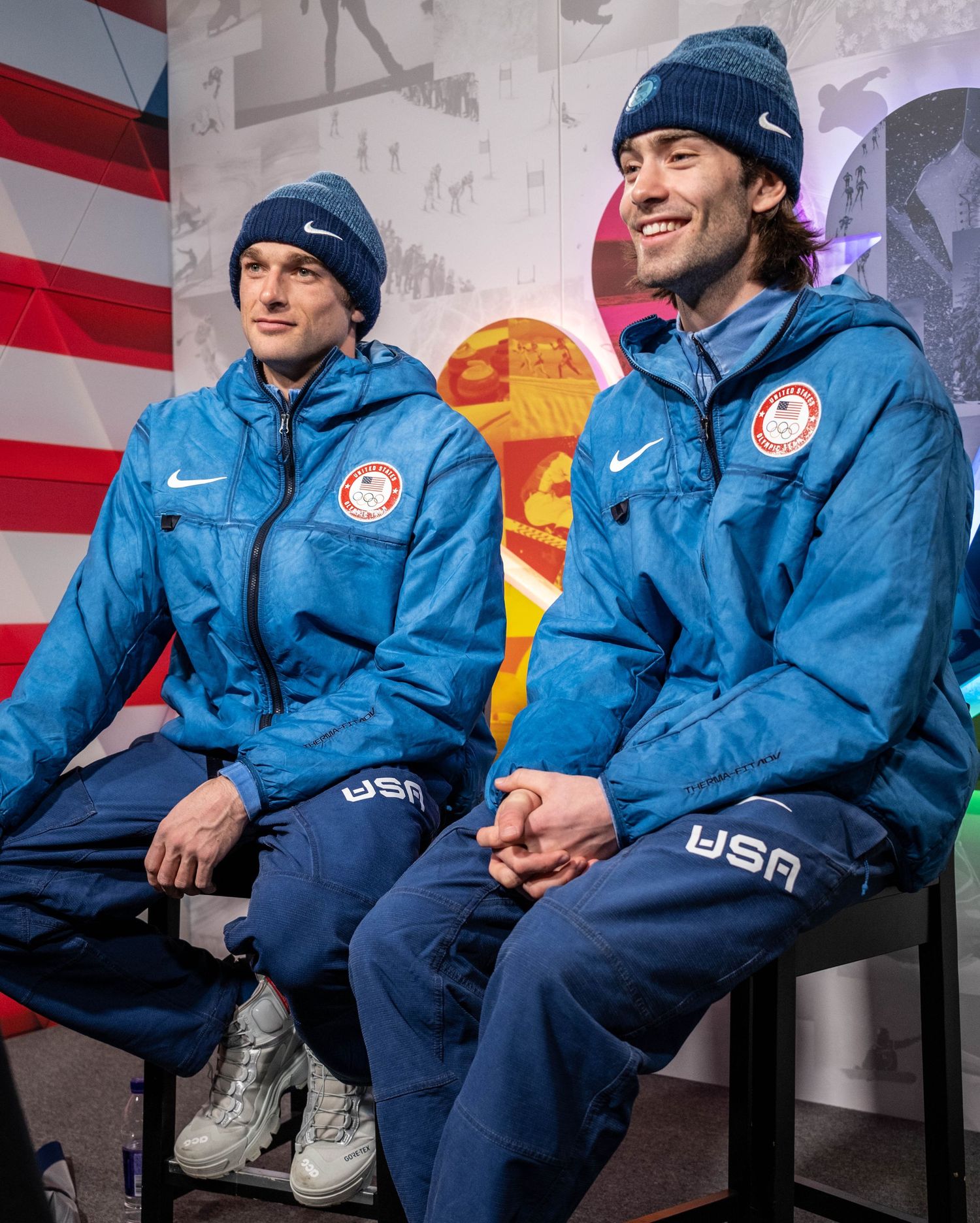 Team USA athletes in blue uniforms sitting during media interview.