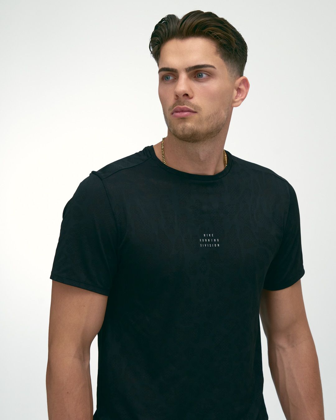A model wearing a black t-shirt with minimal text detail on a white background.