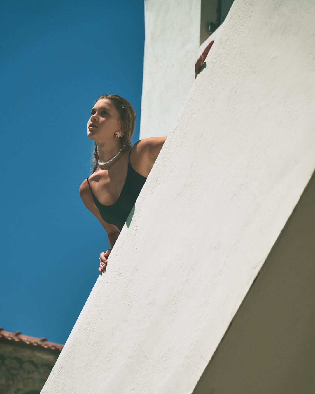 Several architectural shots of a white stucco building against a vivid blue sky from dramatic low angles.