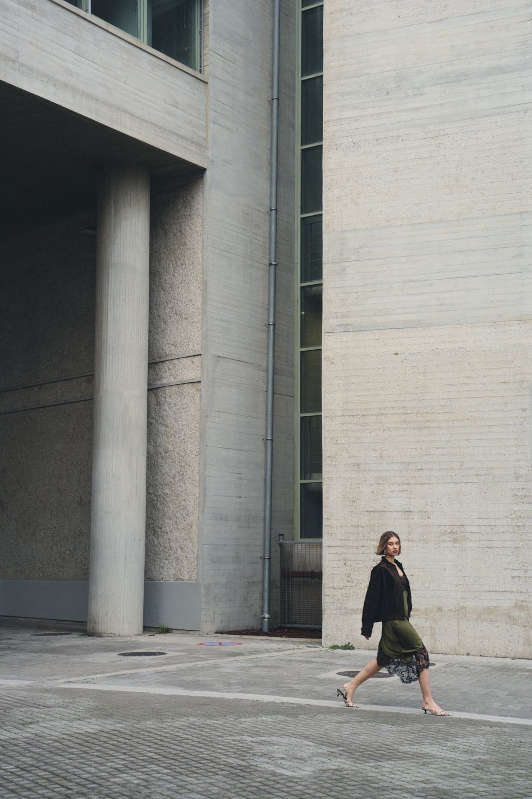A sequence of photos showing a person in business attire walking past a modern concrete building exterior.