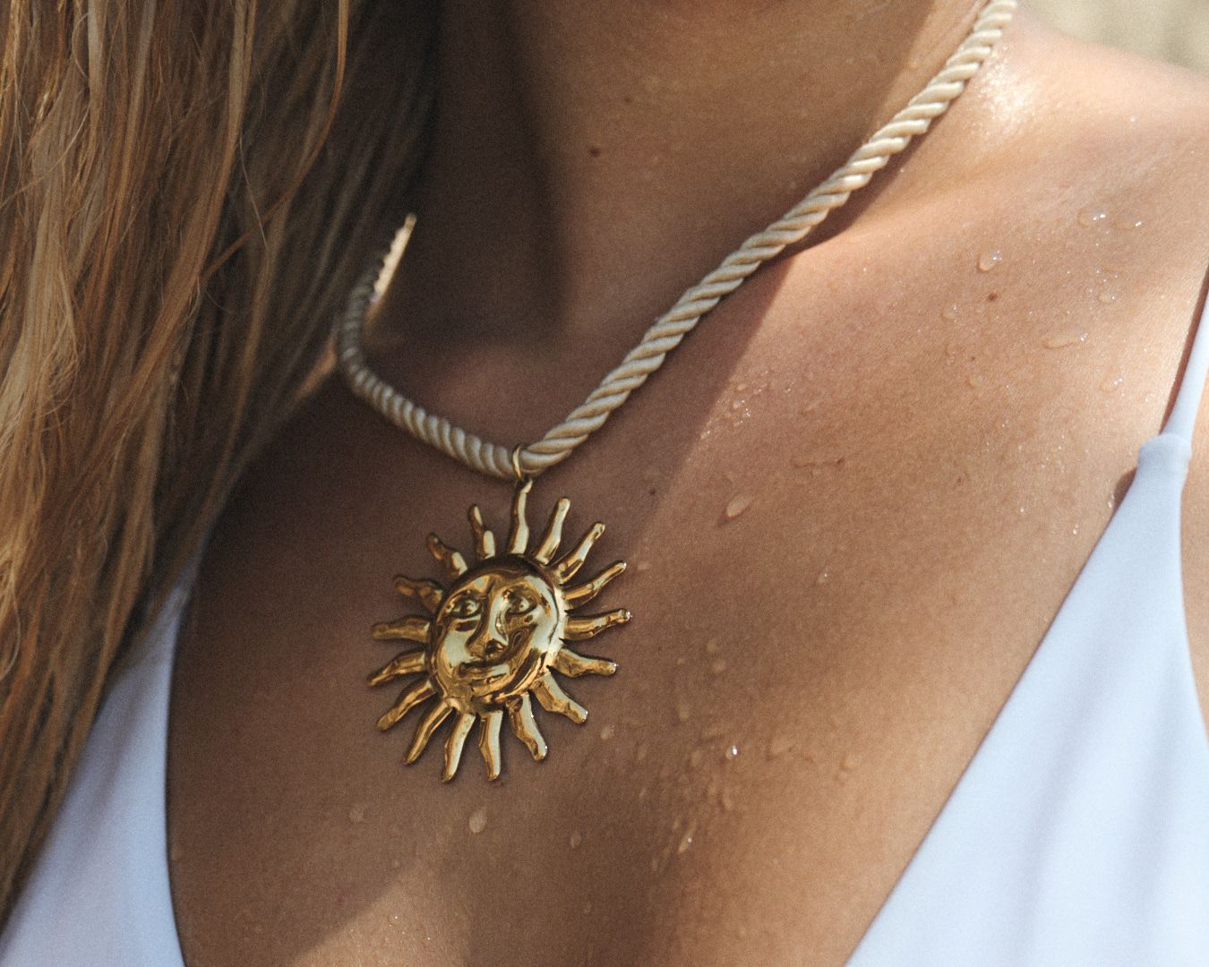 A series of delicate gold sun pendant necklaces displayed on a neutral background, showing different angles.