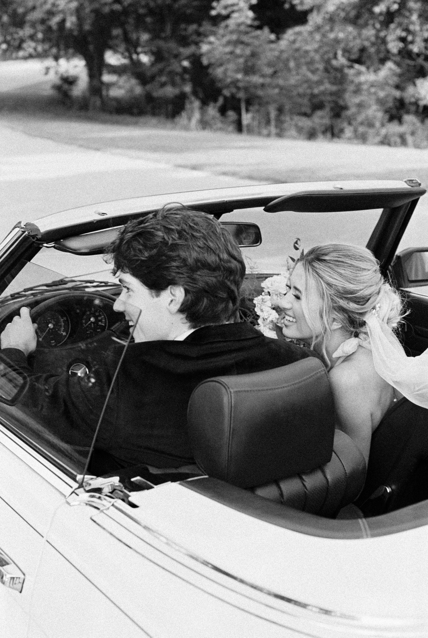 A joyful moment captured in a vintage convertible after the wedding ceremony. Kirstie Whitaker Photography