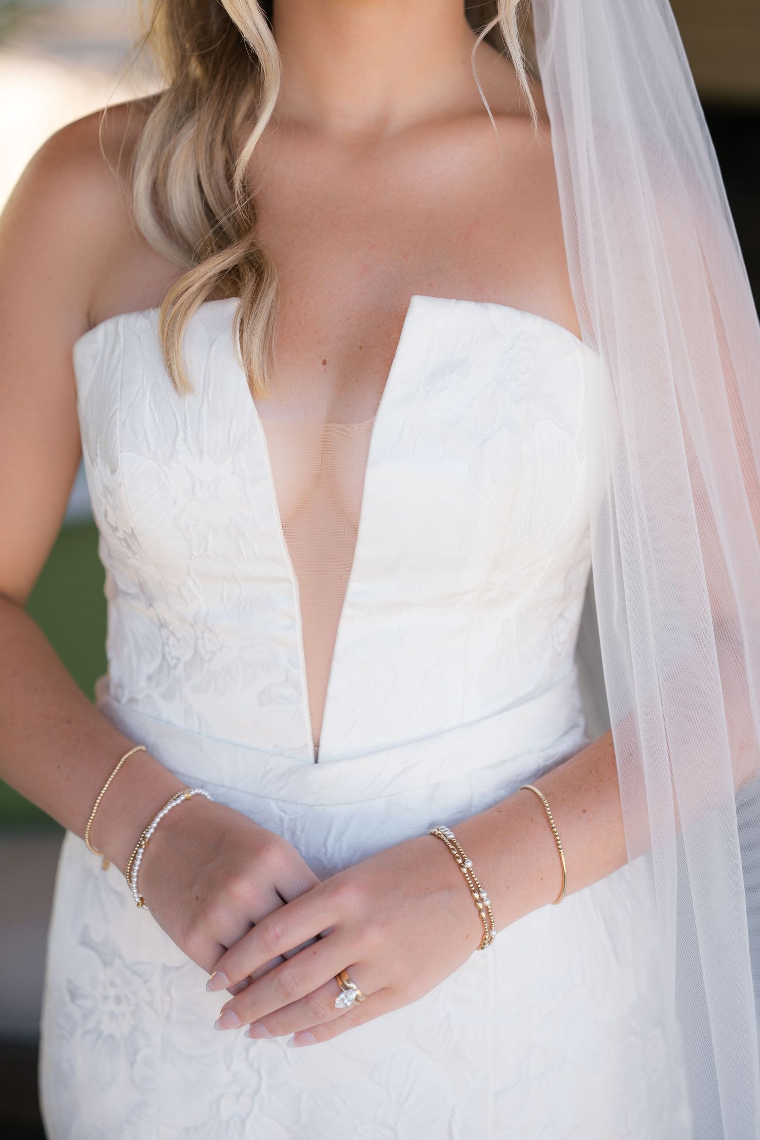 Close-up details of a white lace wedding dress with sweetheart neckline and delicate veil shown in multiple angles.