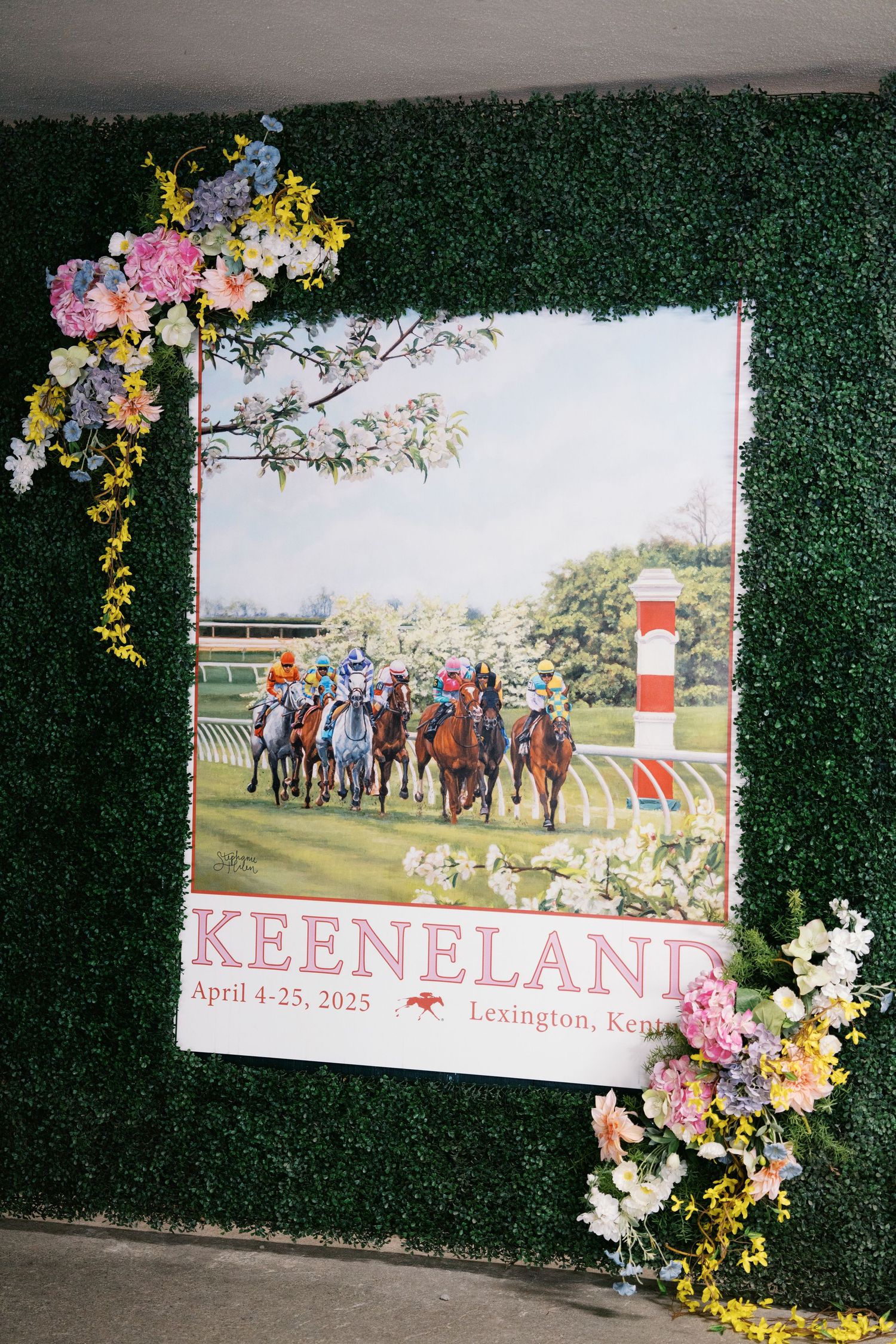 Keeneland racetrack poster with floral decorations displayed on green turf background showing horses racing on the track.
