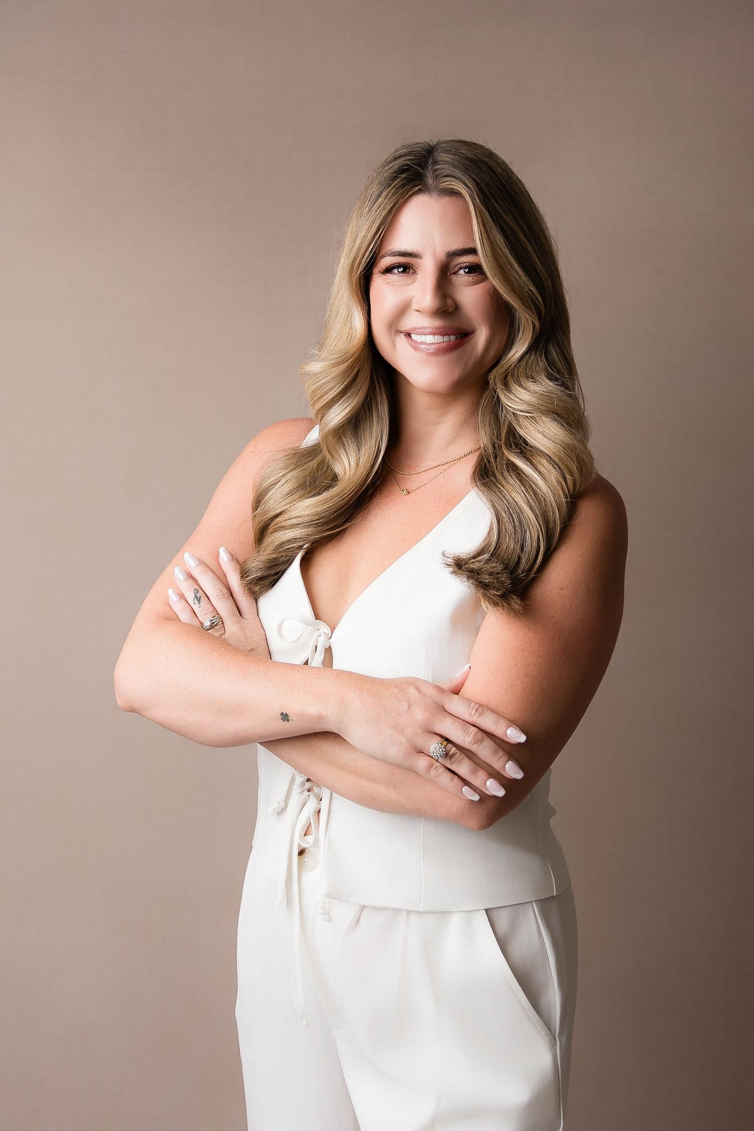 Studio portraits showing a white sleeveless top against a neutral beige background.