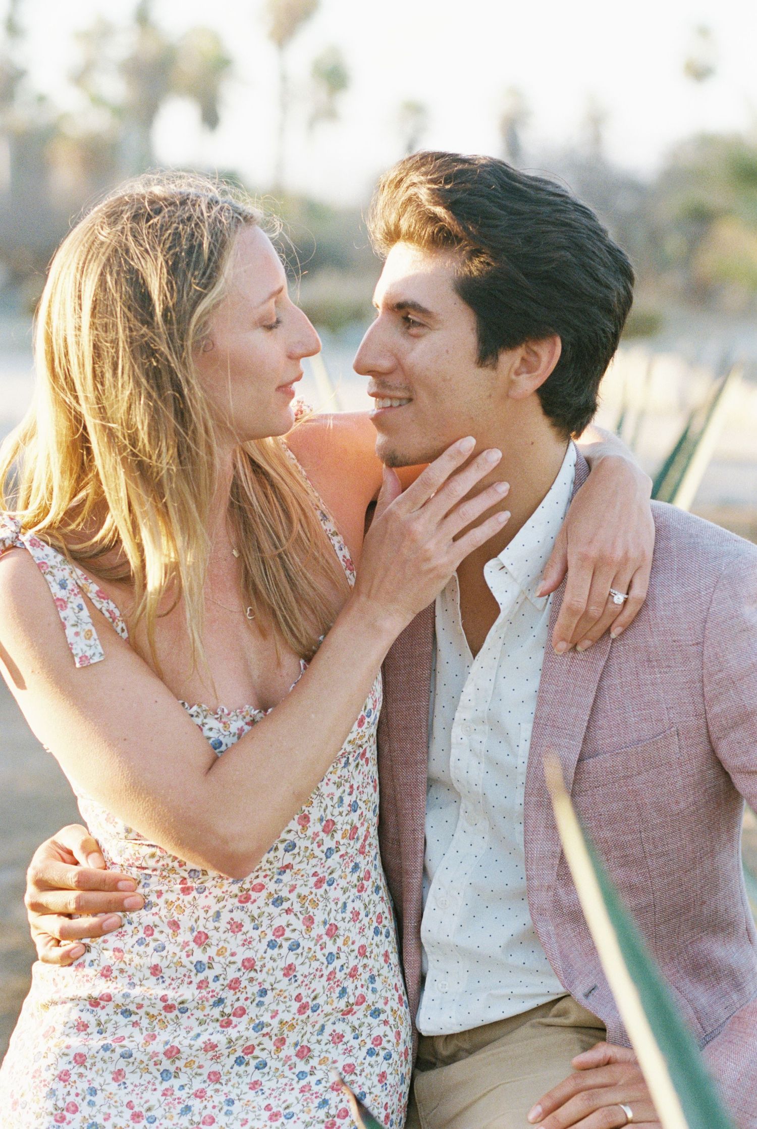 A romantic sunset engagement photo with a couple in casual attire sharing an intimate moment. Kirstie Whitaker Photography