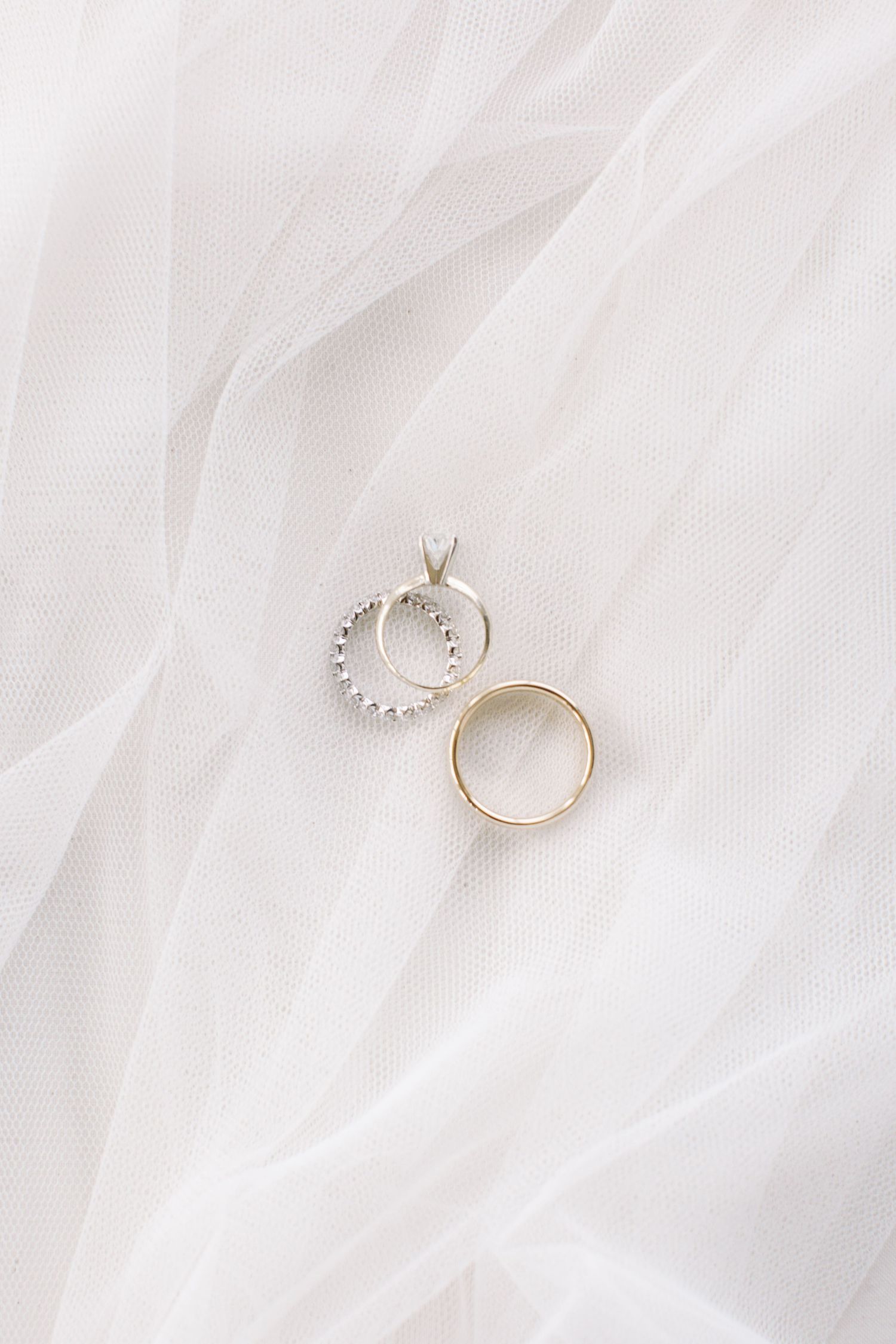 Wedding rings photographed on white tulle fabric in minimalist style. Kirstie Whitaker Photography
