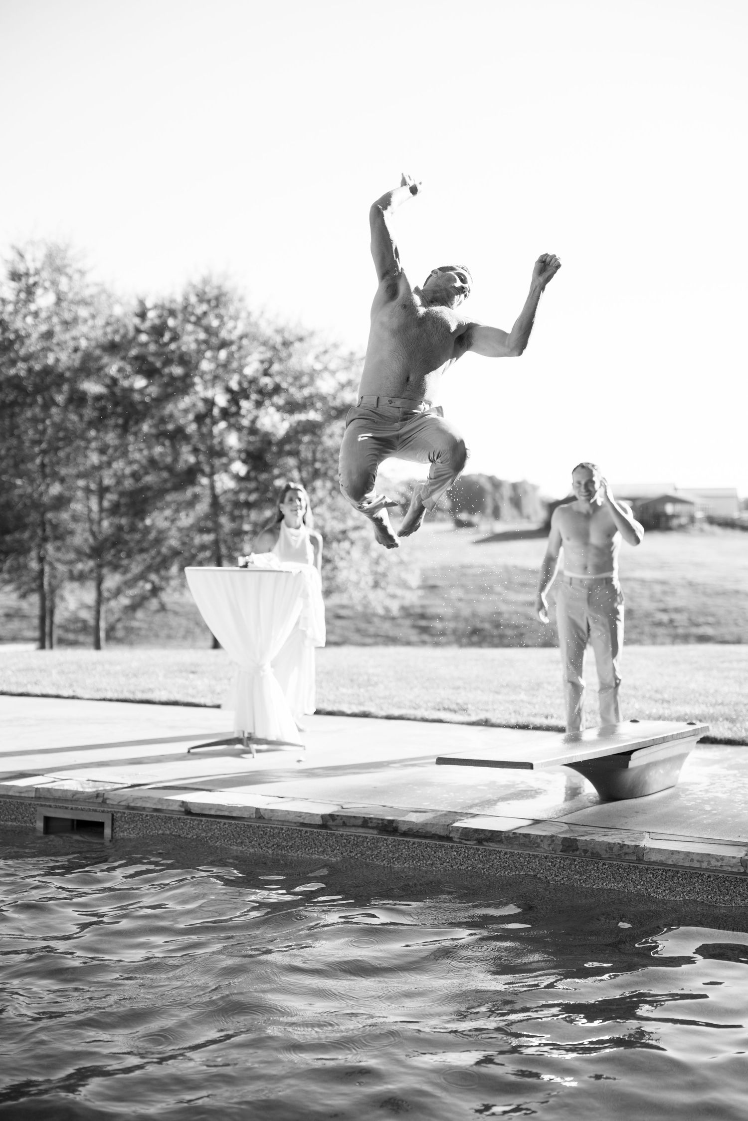 A sequence of black and white photos showing someone doing a backflip dive into a swimming pool.