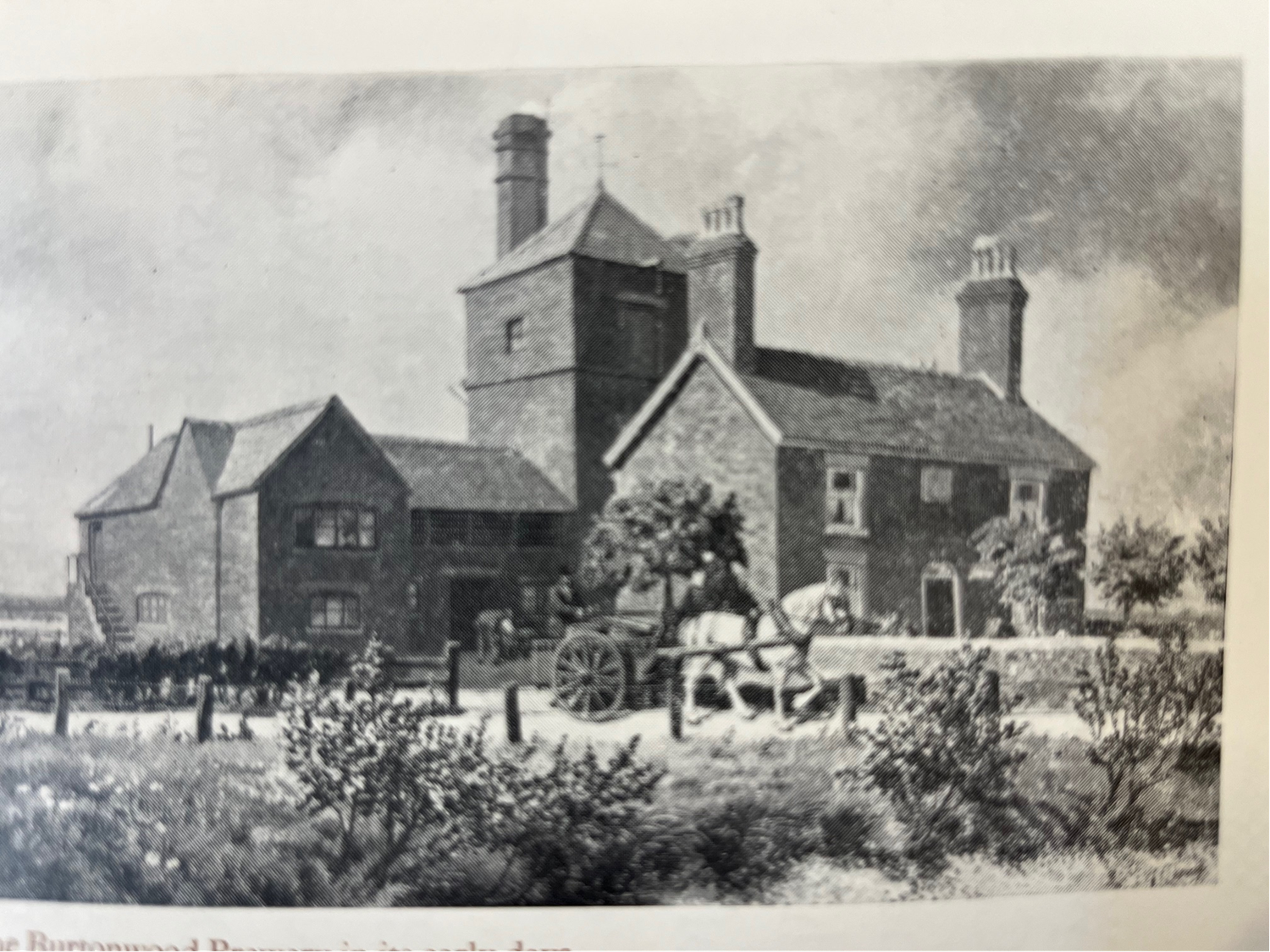 Historic black and white illustration of a traditional English brewery  with horse-drawn cart and figures in foreground.