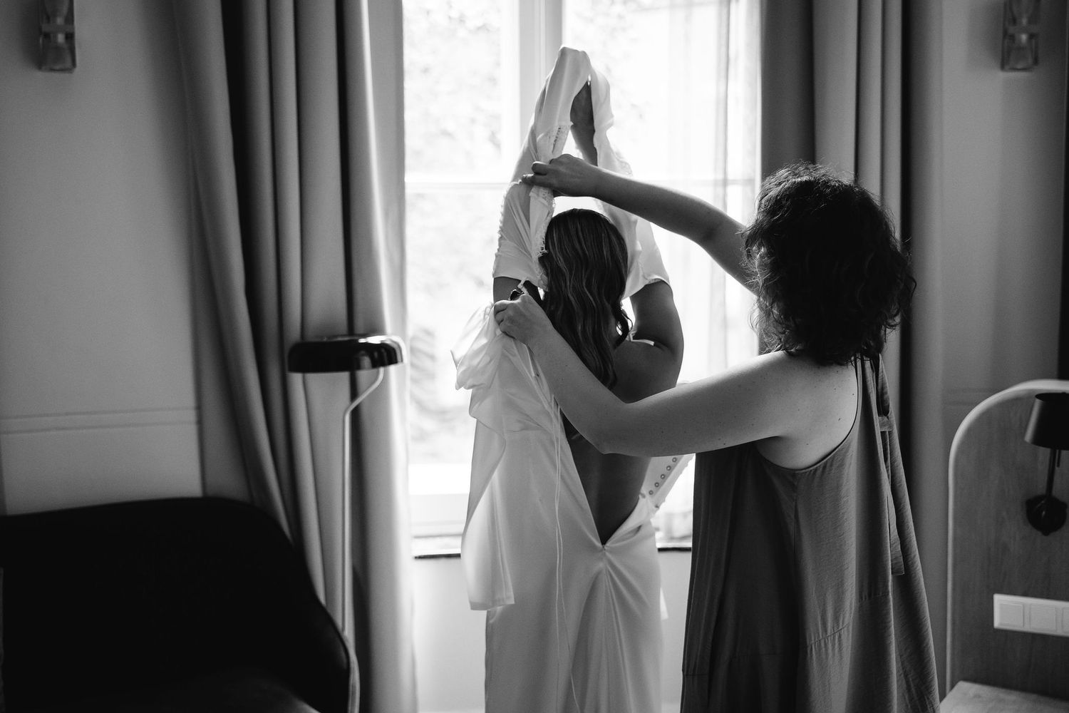 Series of silhouettes showing wedding preparation by window with natural light.