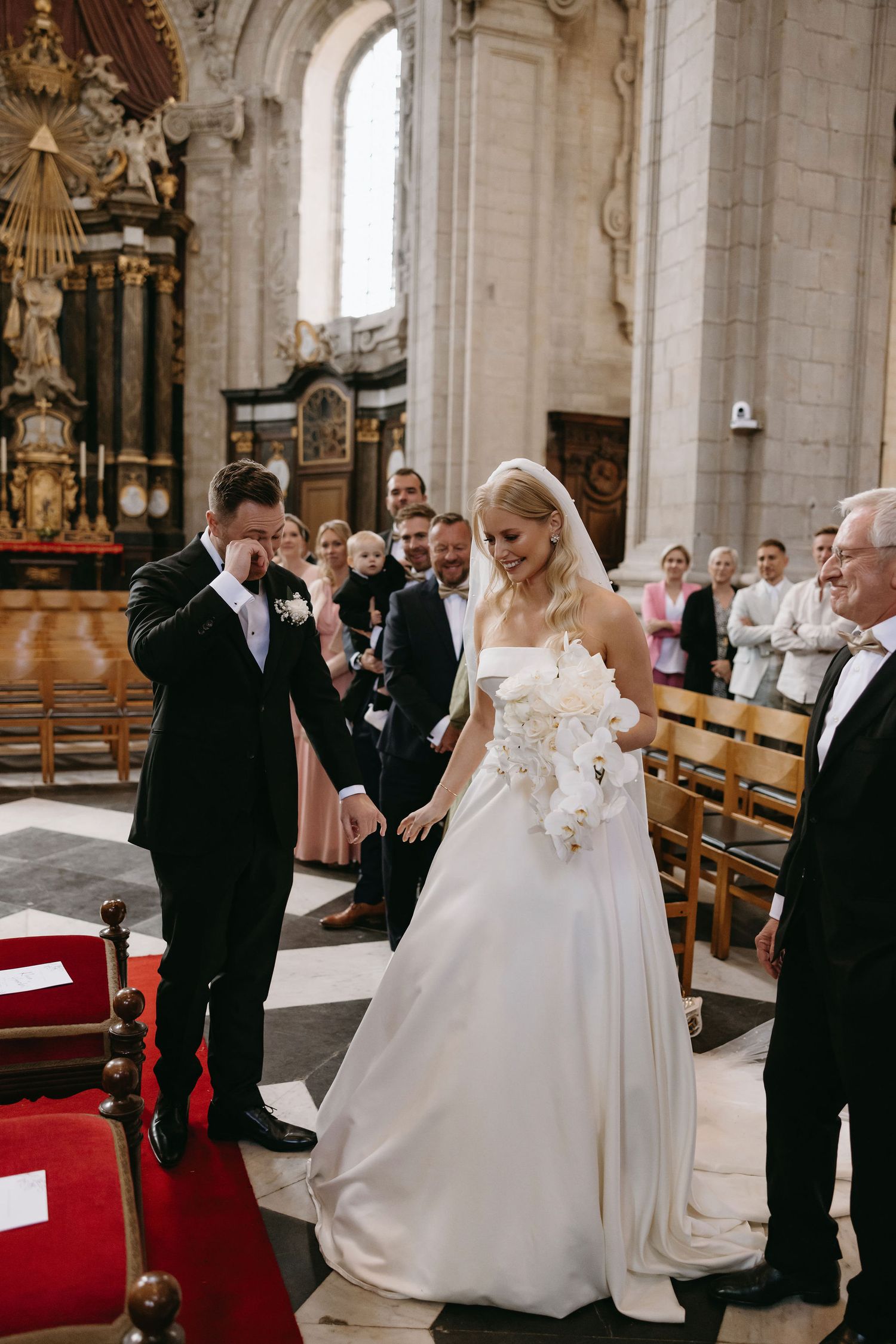 A wedding ceremony moment inside a historic stone church with ornate architectural details.