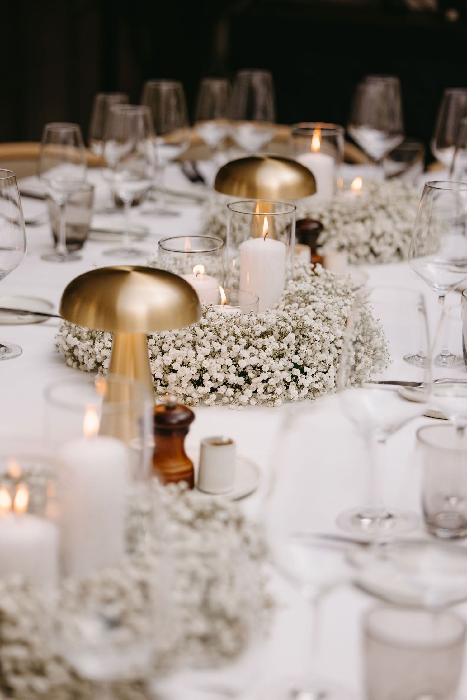 Elegant table setting with gold mushroom decor and baby's breath centerpieces.