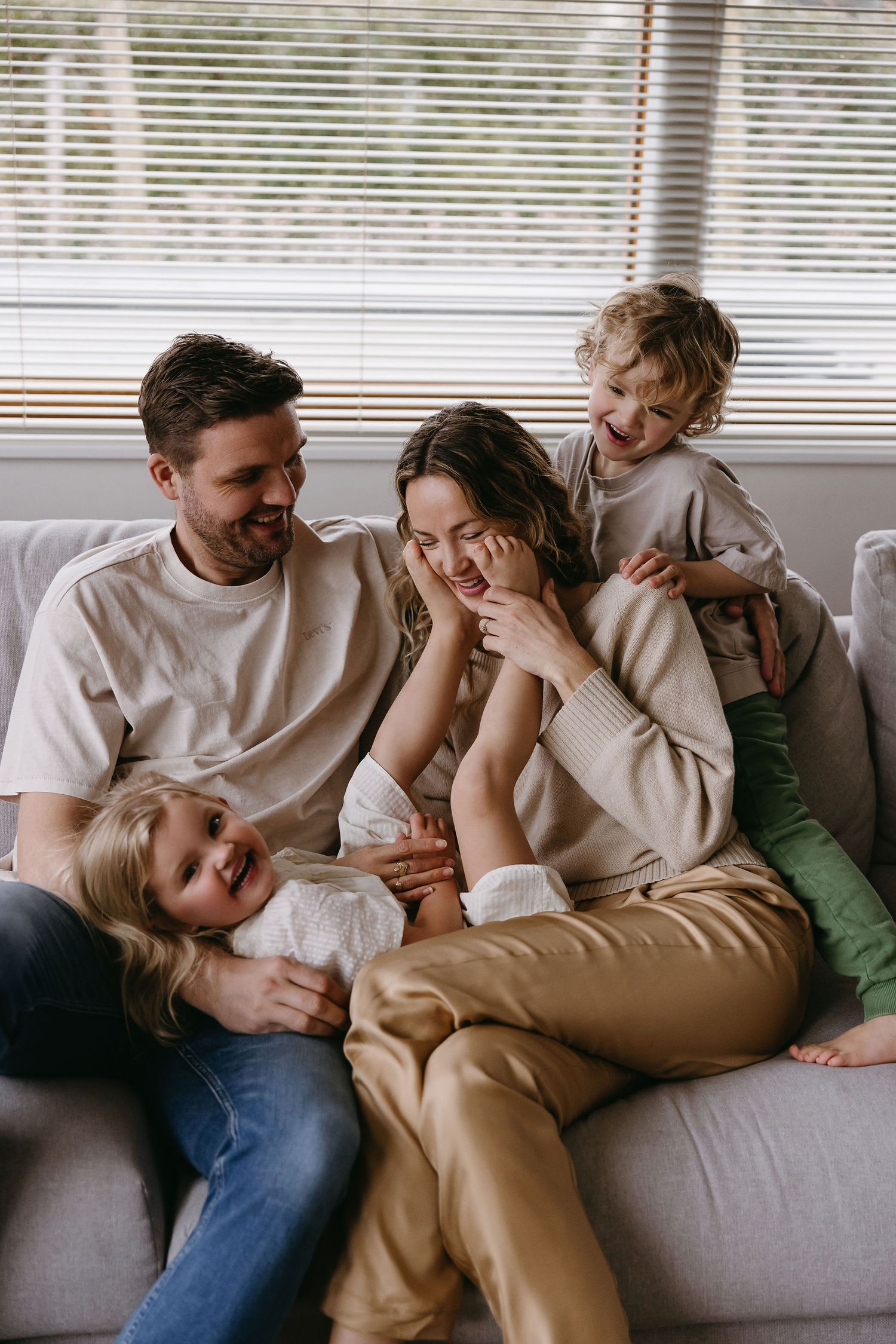 Candid lifestyle photos showing relaxed family moments on a comfortable gray couch.