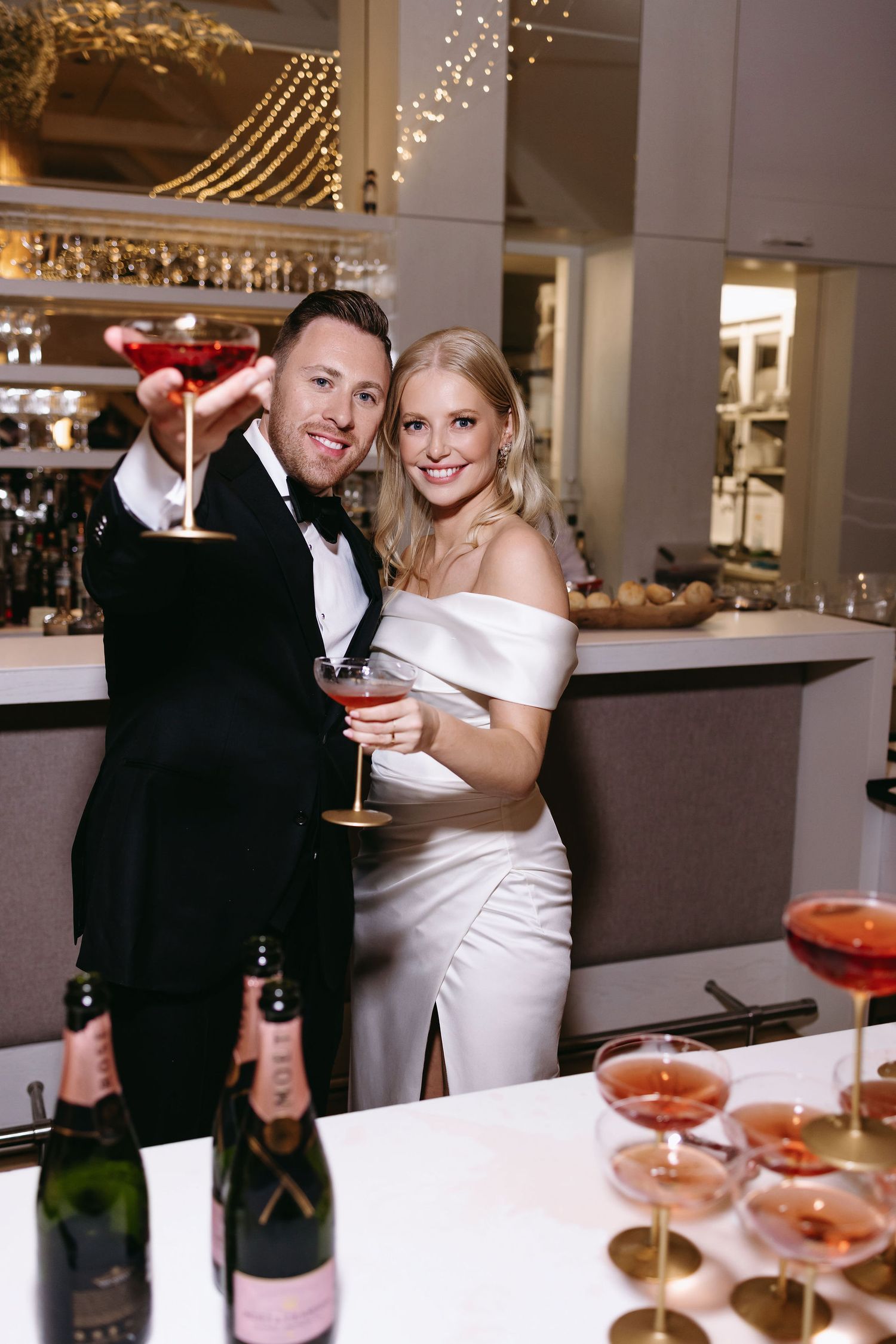 Celebratory moment at wedding reception bar with champagne cocktails.