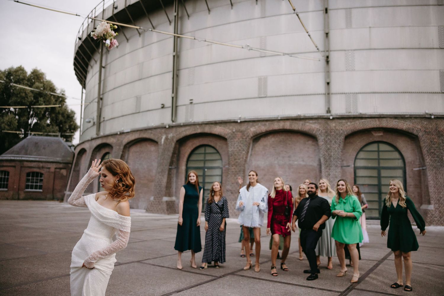 Wedding guests gathered outside a historic building watching the celebration unfold.