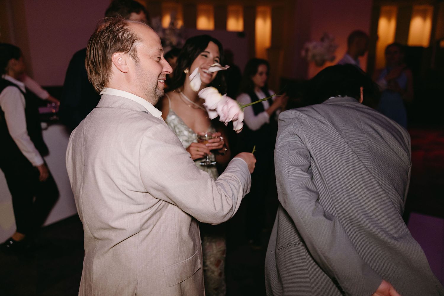 Wedding guests dancing and celebrating enthusiastically at a reception.