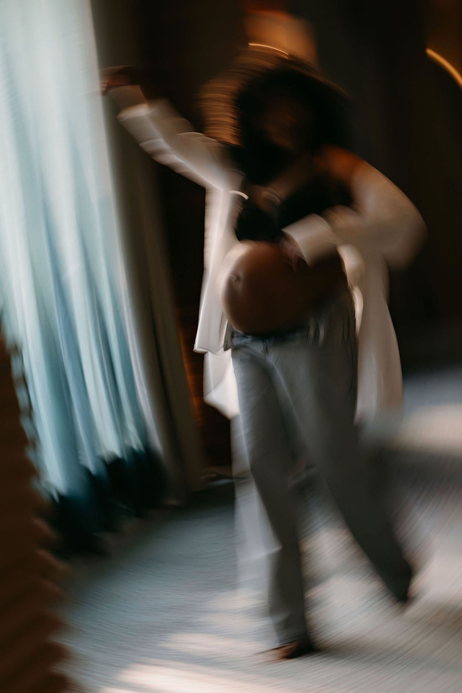 Motion blur maternity portrait with flowing white garments.
