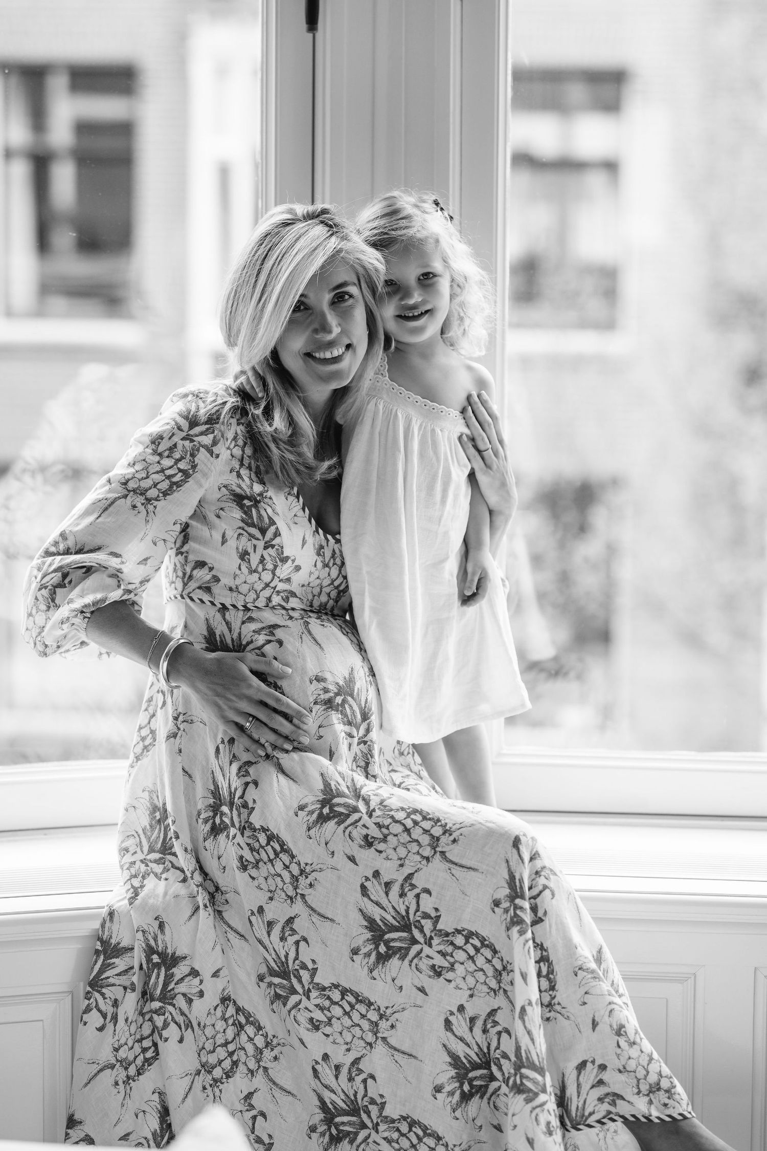 Black and white images showing joyful moments by a sunny window.