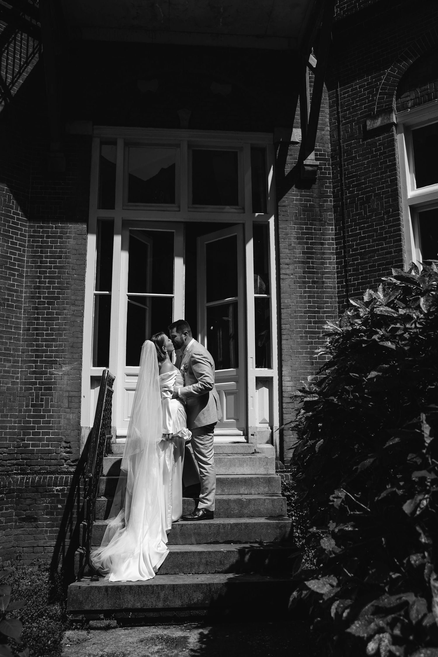 Atmospheric black and white photos showing figures on brick building steps.