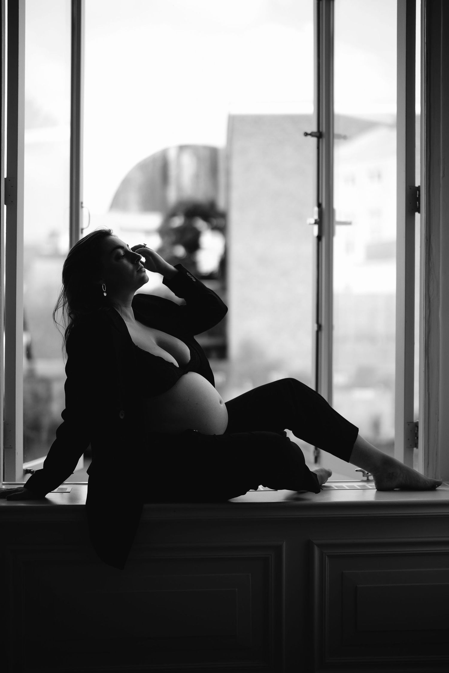 A moody black and white photo series showing someone reclining against windows in silhouette.