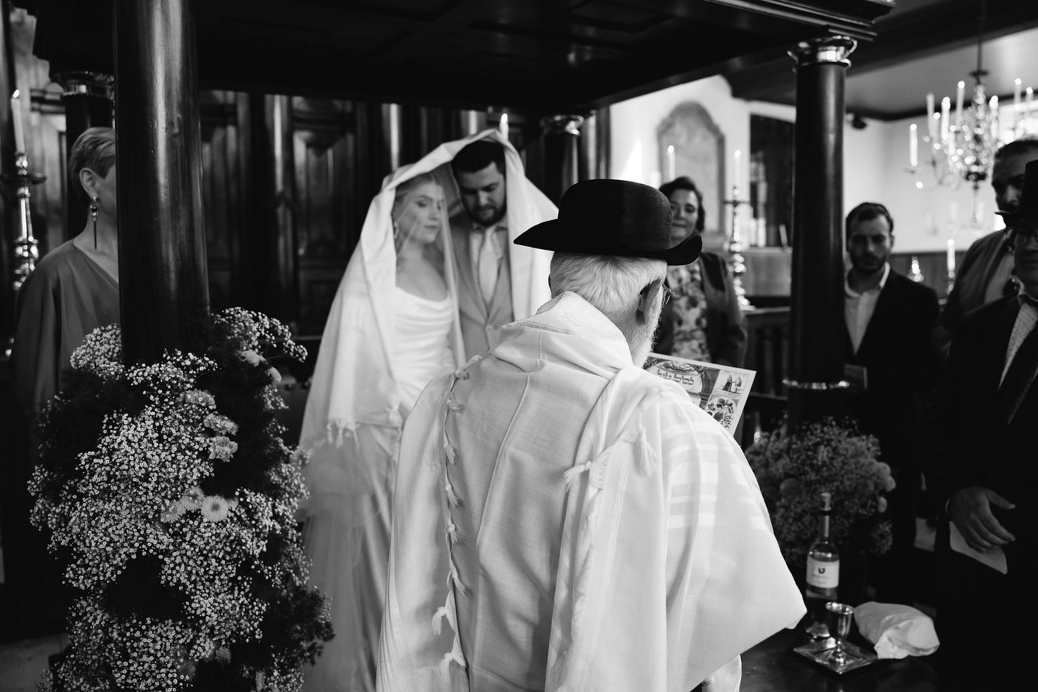 A wedding couple shares an intimate moment at their reception in black and white photography.