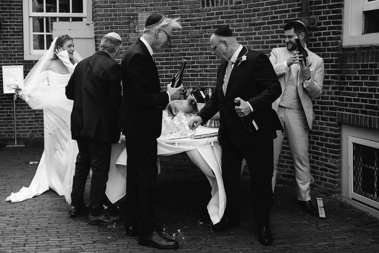 A group gathered around a table signing documents at an outdoor wedding ceremony.