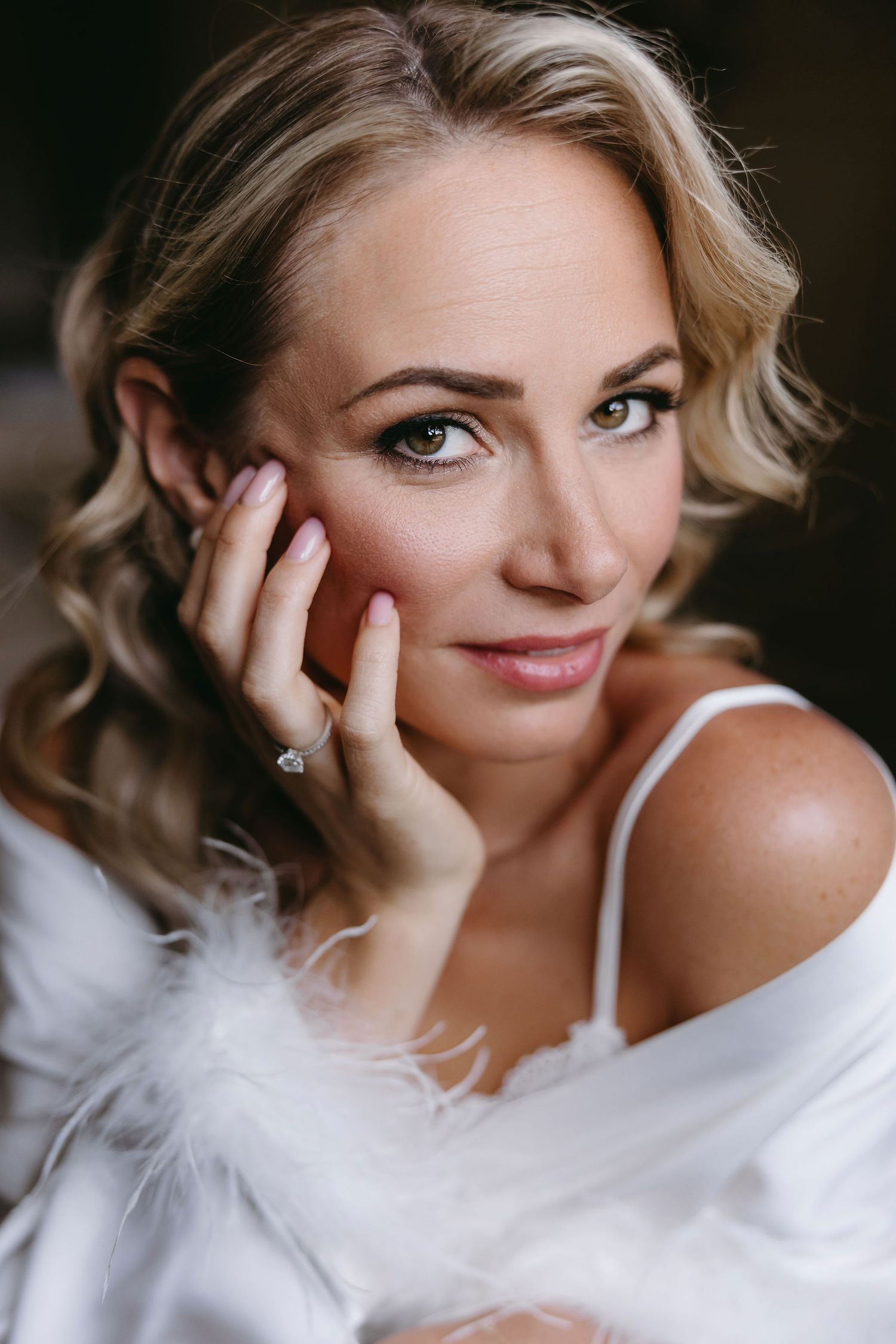 A close-up portrait showing elegant wedding day styling and makeup.